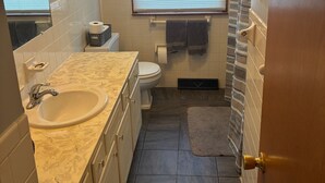 A compact bathroom with a sink, toilet, and shower. - Kansas City World Cup Rental - PRICED RIGHT (Platte City)