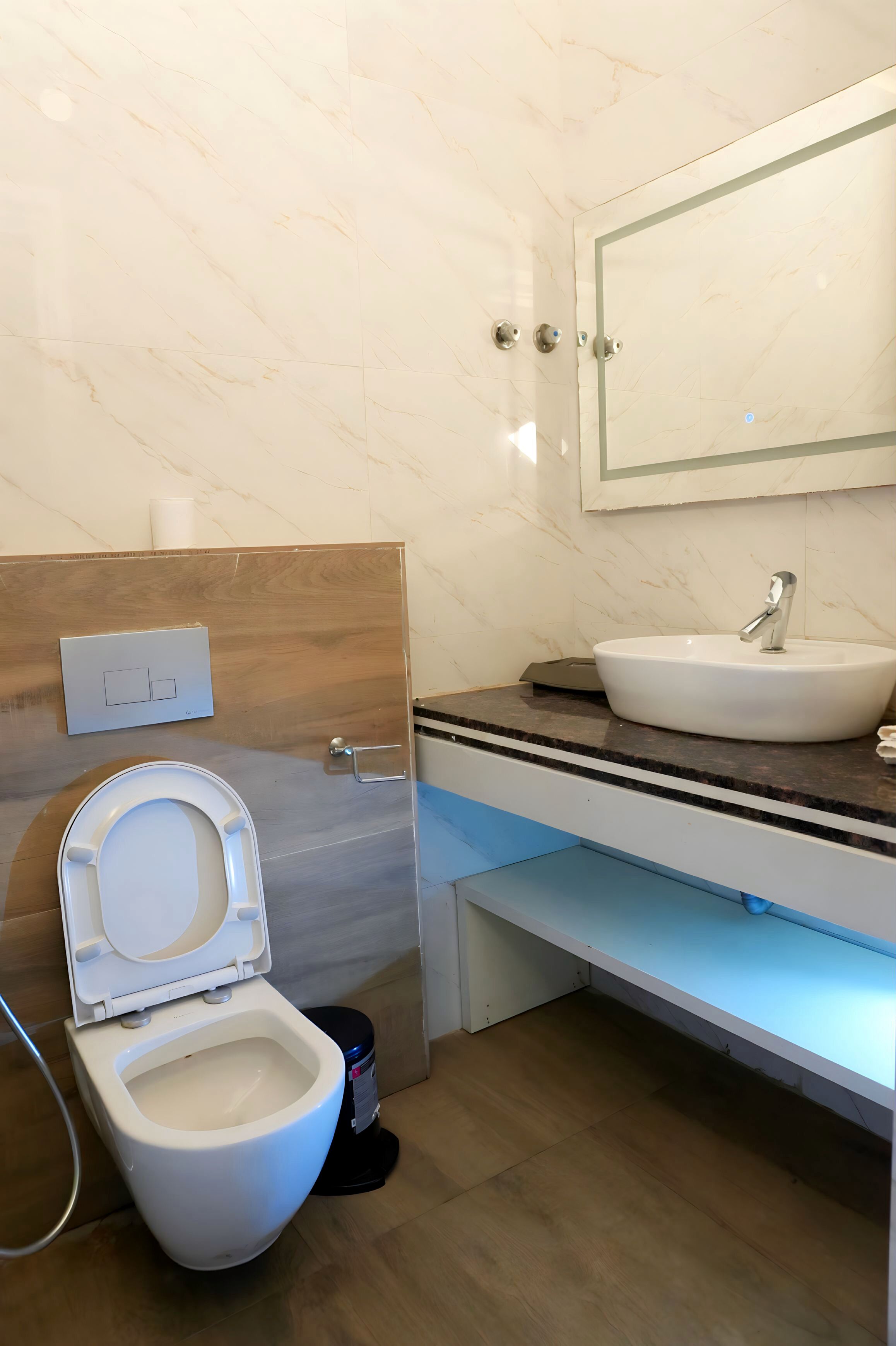 A modern bathroom with a toilet, sink, and mirror.