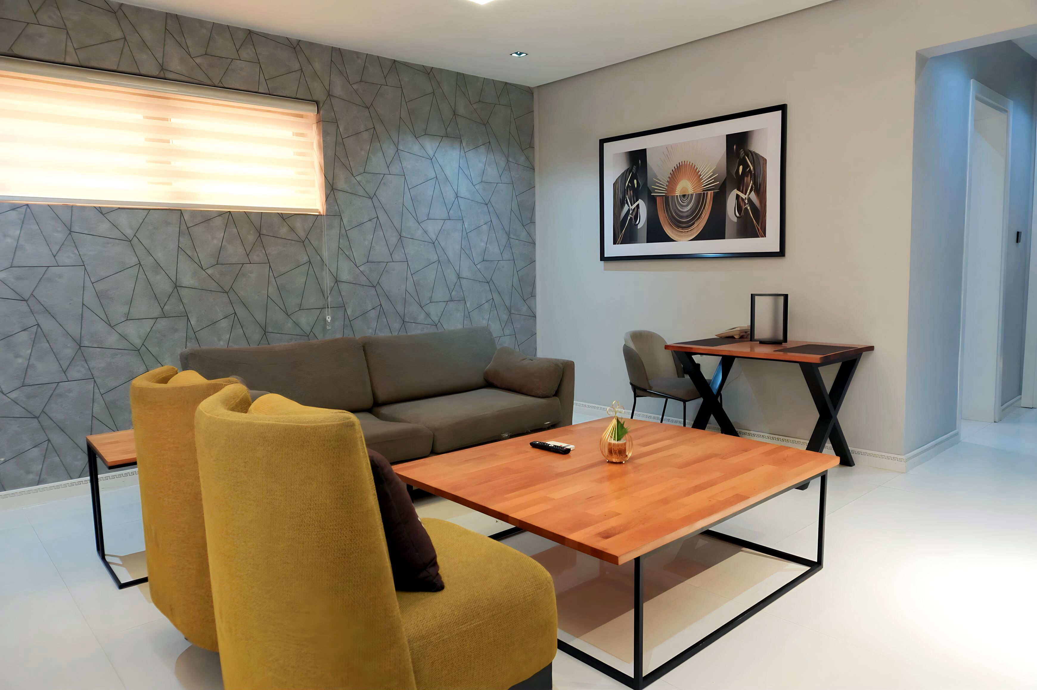 Una sala de estar moderna con una pared gris con estampado, un sofá marrón, sillones amarillos, una mesa de centro de madera y una mesita auxiliar con un florero.