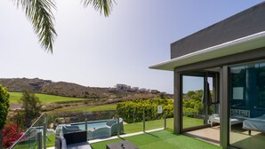 Ein moderner Außenbereich mit Pool, Liegestühlen und Blick auf die umliegende Landschaft.