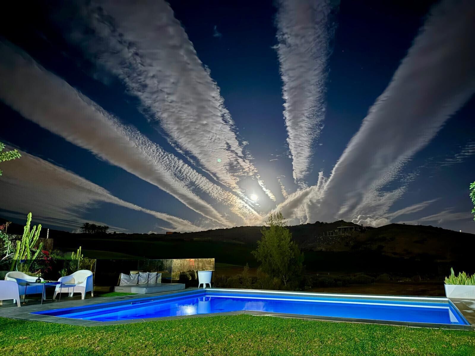 Una piscina con vista al cielo y un paisaje lejano.