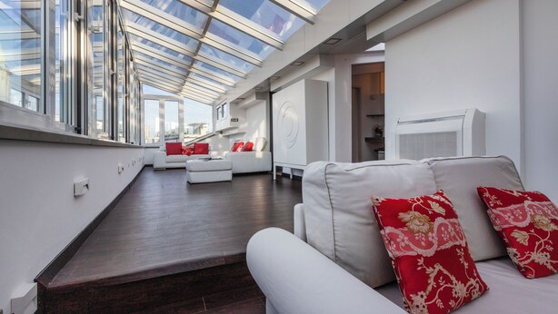 A modern living room with a skylight, white sofas, and red patterned cushions. - Italianway Comfort - Torino 57 B (Milano)
