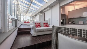 A modern kitchen with a skylight, a dining area with white furniture, and a view of the city through large windows. - Italianway Comfort - Torino 57 B (Milano)