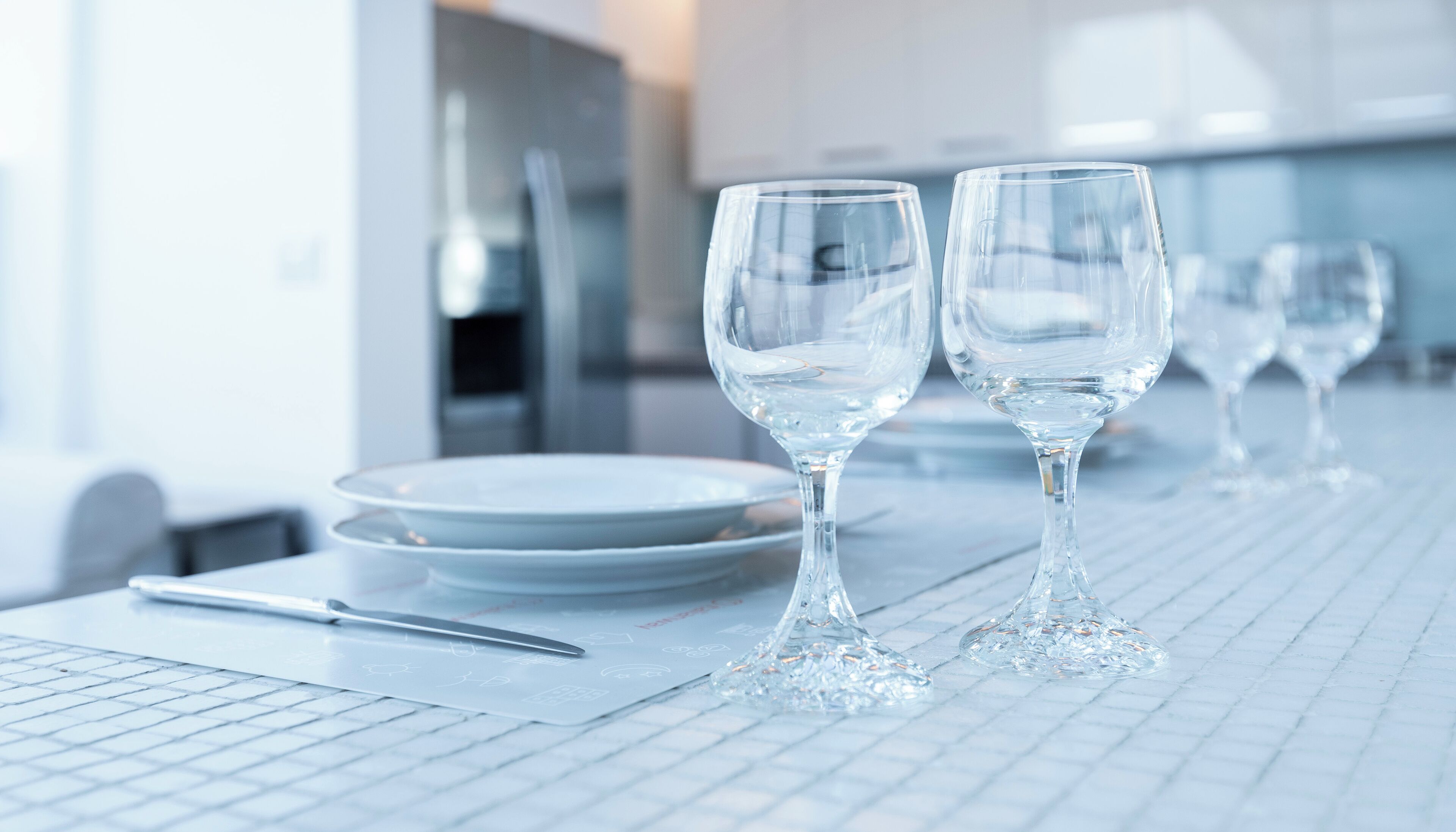 Un comedor limpio y moderno con vajilla y vasos blancos.