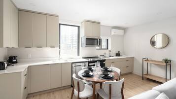 Una cocina moderna con comedor, electrodomésticos integrados y un diseño minimalista.