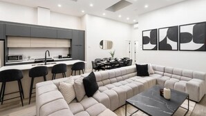 A modern living space with a kitchen, dining area, and seating area. - The Griffin (Montréal)