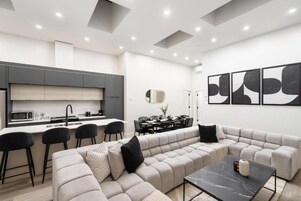 A modern living space with a kitchen, dining area, and seating area.