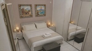 Een slaapkamer met een bed, nachtkastjes, een spiegel en kunst aan de muur.