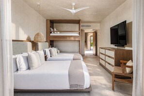 A hotel room with two beds, a TV, and a wooden desk.
