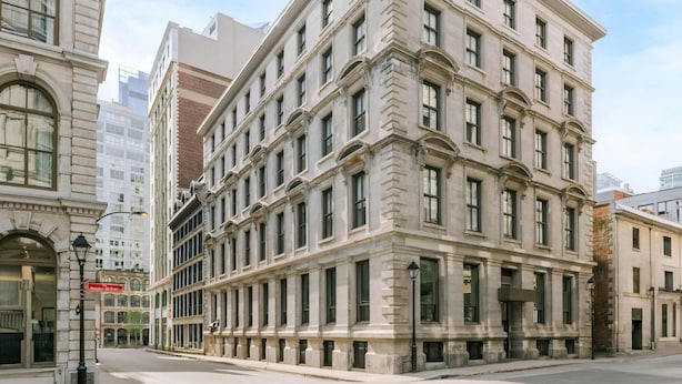 A multi-story building with a classical architectural style, featuring large windows and a symmetrical facade.