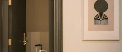 A doorway leading to a room with a framed abstract artwork on the wall.