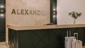 A reception desk with the name 'ALEXANDER' prominently displayed.