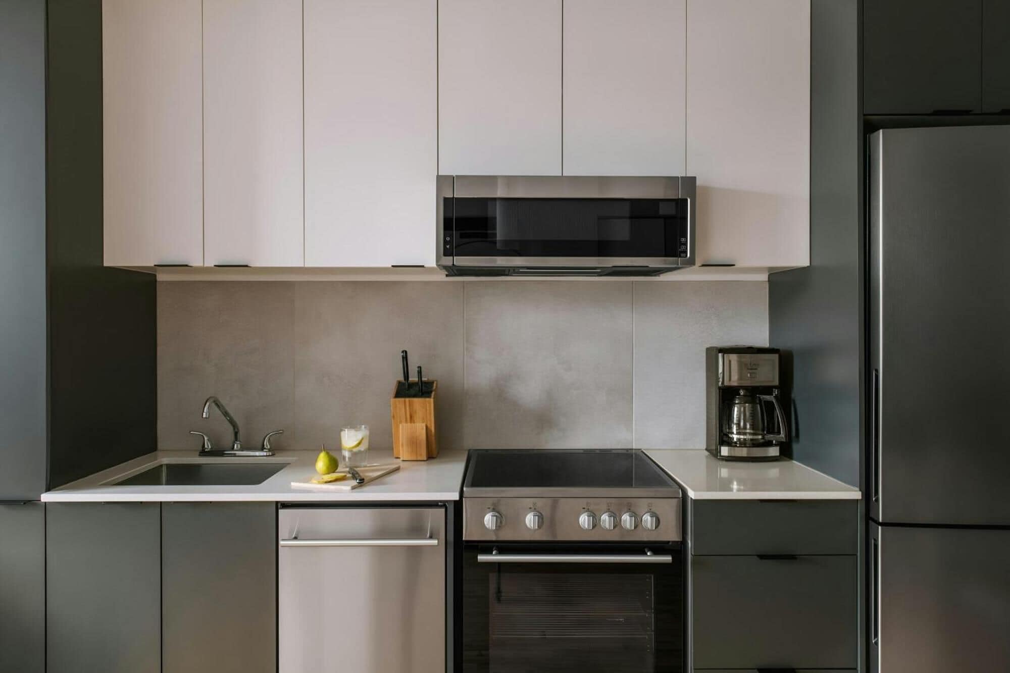 A modern kitchen with a built-in oven, microwave, and coffee maker.