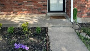 A residential house with a brick exterior, a black front door, and a window on the left side. - A Home for guests on Budget. (Broken Arrow)
