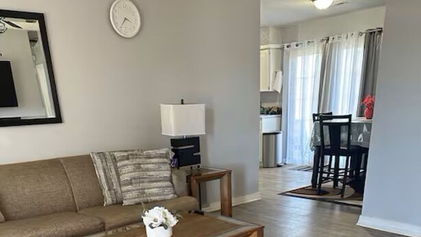 A living room with a sofa, coffee table, and a patterned rug. - A Home for guests on Budget. (Broken Arrow)