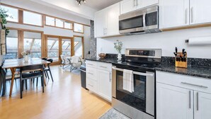 A modern kitchen with white cabinets, a stainless steel oven, and a microwave. - Blue Mountain Retreat | Sunset Views | Fire Pit (Alexander)