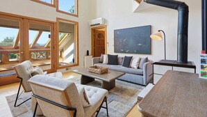A spacious living area with a sofa, chairs, a coffee table, and a fireplace. - Blue Mountain Retreat | Sunset Views | Fire Pit (Alexander)