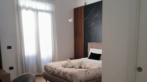 Un dormitorio moderno con cama, una silla y un escritorio.
