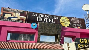Um hotel com uma grande placa anunciando novas acomodações com preço reduzido.