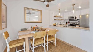 Una cocina moderna con armarios blancos, un refrigerador de acero inoxidable y un microondas.