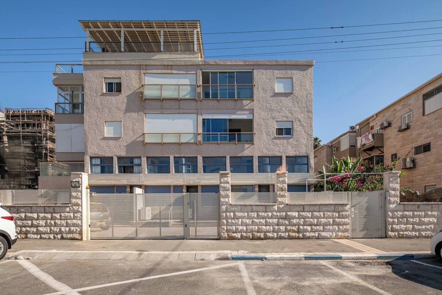A multi-story building with a gated entrance, a flat roof with solar panels, and a brick facade.