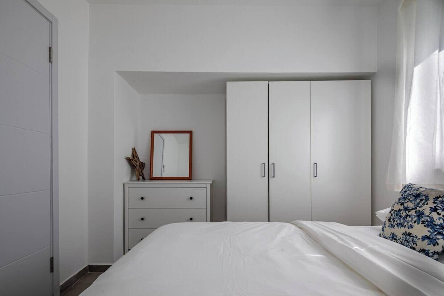 Une chambre à coucher avec un lit, une commode et une armoire.