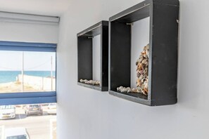 Two black-framed wall-mounted shelves with seashells and pebbles. - Port city - beachfront 5 bdrms apartment+ mamad (Haifa)