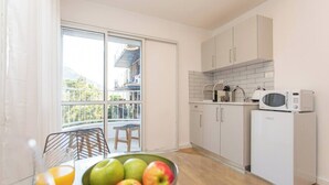 Una cocina moderna con alacenas blancas, un microondas y un refrigerador.