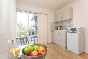 Eine moderne Küche mit weißen Schränken, einer Mikrowelle und einem Kühlschrank.