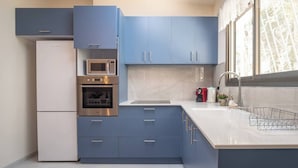 A modern kitchen with blue cabinets, a stainless steel oven, a microwave, and a sink. - Port city haifa - 1 bdrm apt Near beach 2 (Haifa)