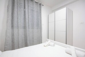 A bedroom with a bed, a large mirror, and a curtain. - Port city-german colony 2 bdrms w/balcony+mamad 1 (Haifa)