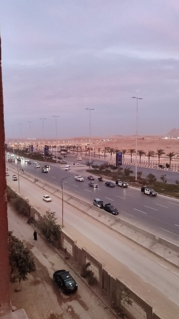 A highway with multiple lanes of traffic, palm trees, and streetlights.