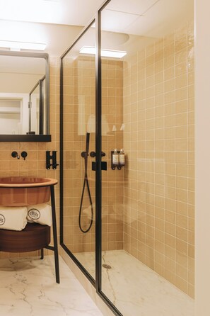 A modern bathroom with a glass-enclosed shower, a marble sink, and beige tiled walls. - Gran Cruz Apartments (Vila Nova de Gaia)