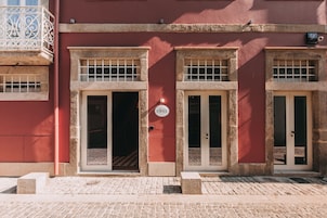 Un edificio con tres puertas, cada una con un ventanal encima.