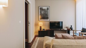 A hotel room with a bed, a TV, a desk, and a chair.