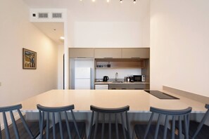 Une cuisine moderne dotée d’un îlot central, de tabourets de bar et d’une table à manger.