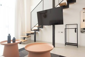 A modern interior with a staircase, a flat-screen TV mounted on a wall, and a minimalist design. - Port city haifa-Urbanic Loft heart of haifa Dwntwn (Haifa)