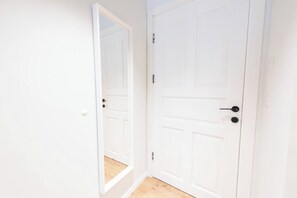 A hallway with two white doors, one with a visible handle and the other with a lock. - Port city haifa - authentic 1 bdrm germancolony 4 (Haifa)