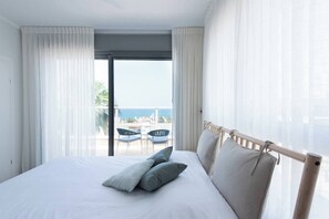 A hotel room with a bed, a balcony with chairs, and a view of the sea. - Port city haifa - SeaView 1 bdrm Penthouse (Haifa)