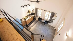 Una cocina con comedor, ventilador de techo y ventana con cortinas.