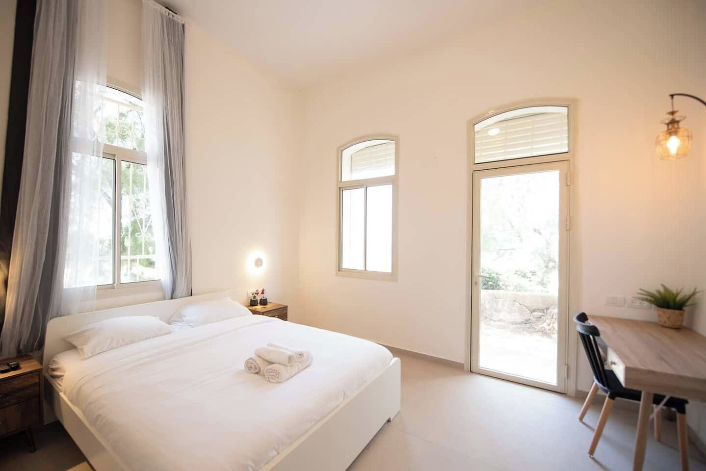 Ein Hotelzimmer mit einem Bett, einem Schreibtisch und zwei Fenstern.