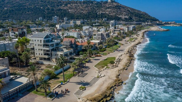 Une ville côtière dotée de bâtiments modernes, d’une plage et d’un littoral rocheux.