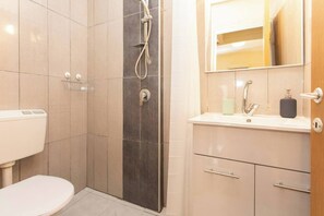 Ein modernes Badezimmer mit Toilette, Dusche und Waschbecken.
