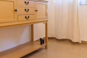 A wooden cabinet with drawers and a shelf, a curtain, and a tiled floor. - Downtown Haifa Studio 212, Near Port, AC & WiFi (Haifa)