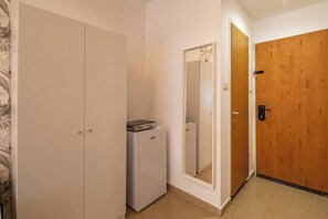 A hallway with a white wardrobe, a small appliance, and a wooden door. - Downtown Haifa Studio 212, Near Port, AC & WiFi (Haifa)