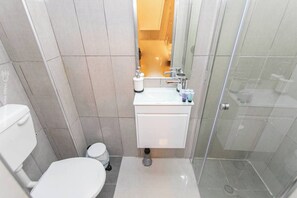 Ein modernes Badezimmer mit Toilette, Waschbecken und Dusche.