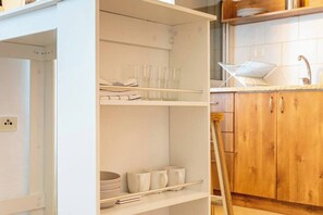 Eine Küche mit weißen Schränken, einer Holz Arbeitsplatte und einem Spülbecken.