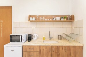 A kitchen with a microwave, coffee maker, kettle, and a sink. - Port city haifa - Studio 216 (Haifa)