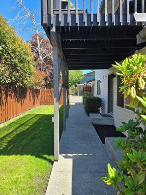 A residential property with a covered porch, a wooden fence, and a well-maintained lawn.