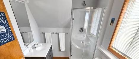 Douche, baignoire à remous, séchoir à cheveux, serviettes fournies